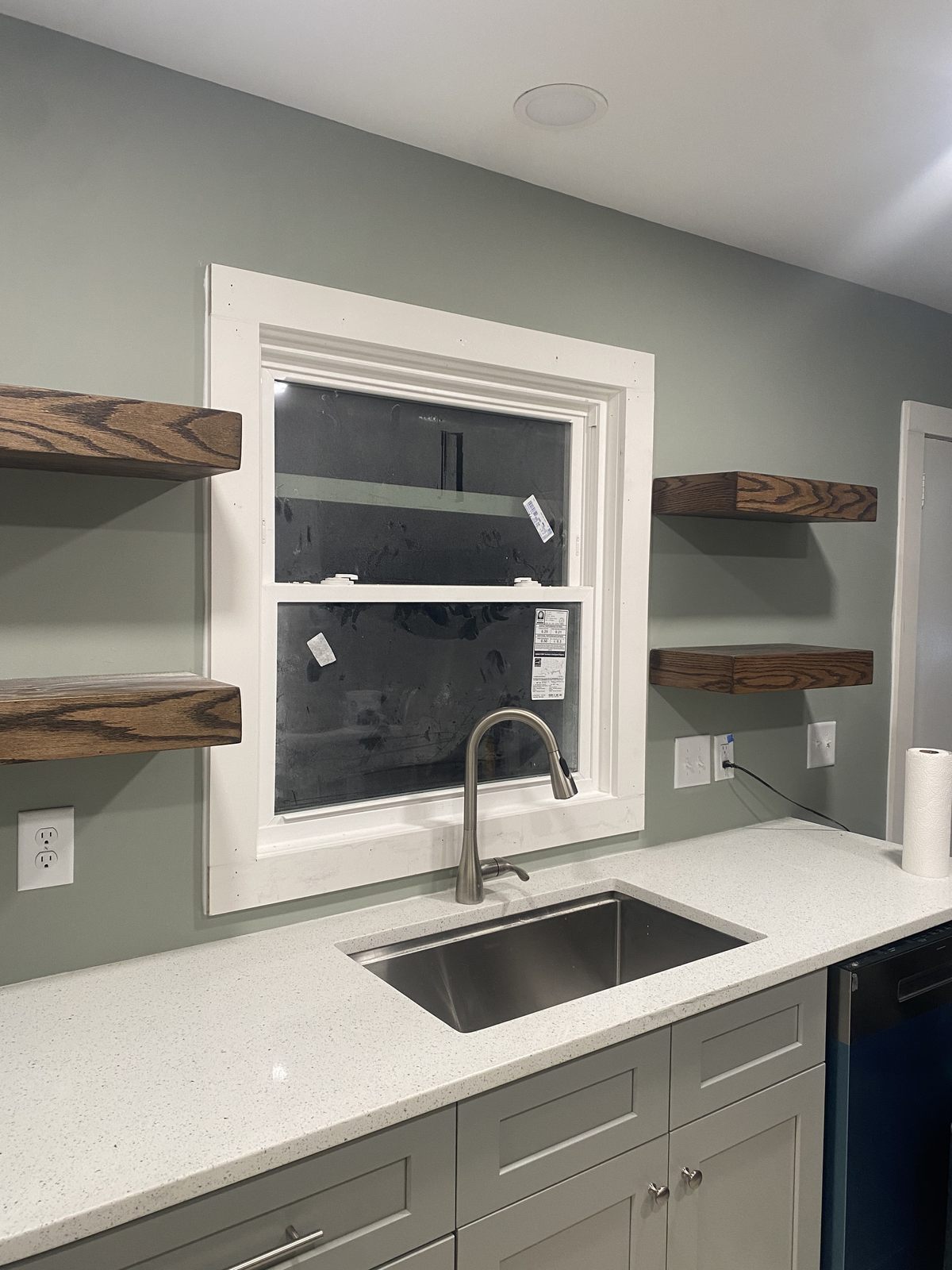 Custom floating wood shelves and a quartz wet bar with sink