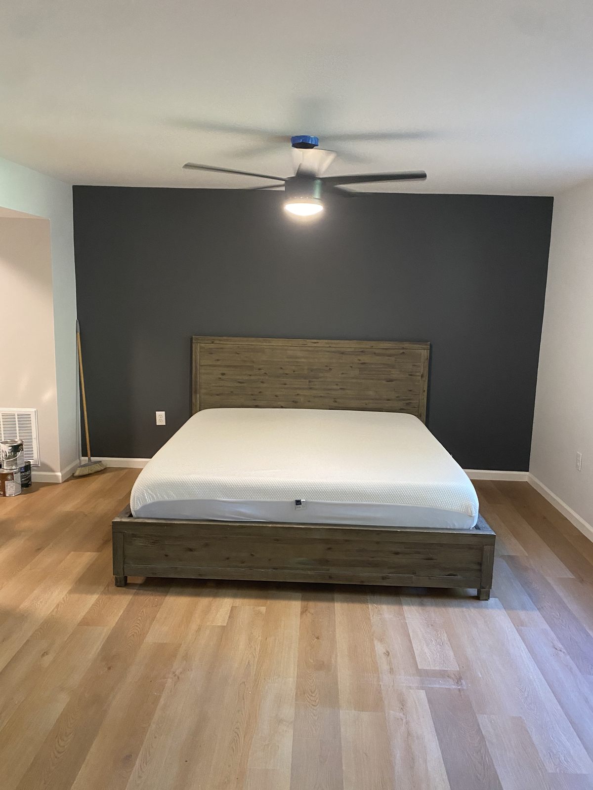 Remodeled bedroom with an accent wall and hardwood flooring